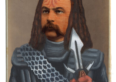 A vintage portrait photo in the style of Alex Gross, altered to depict a man as a Klingon warrior from Star Trek, with long hair, ridged forehead, armor, and a Klingon weapon. The card reads "W.A. Locke, La Salle, ILL." at the bottom.