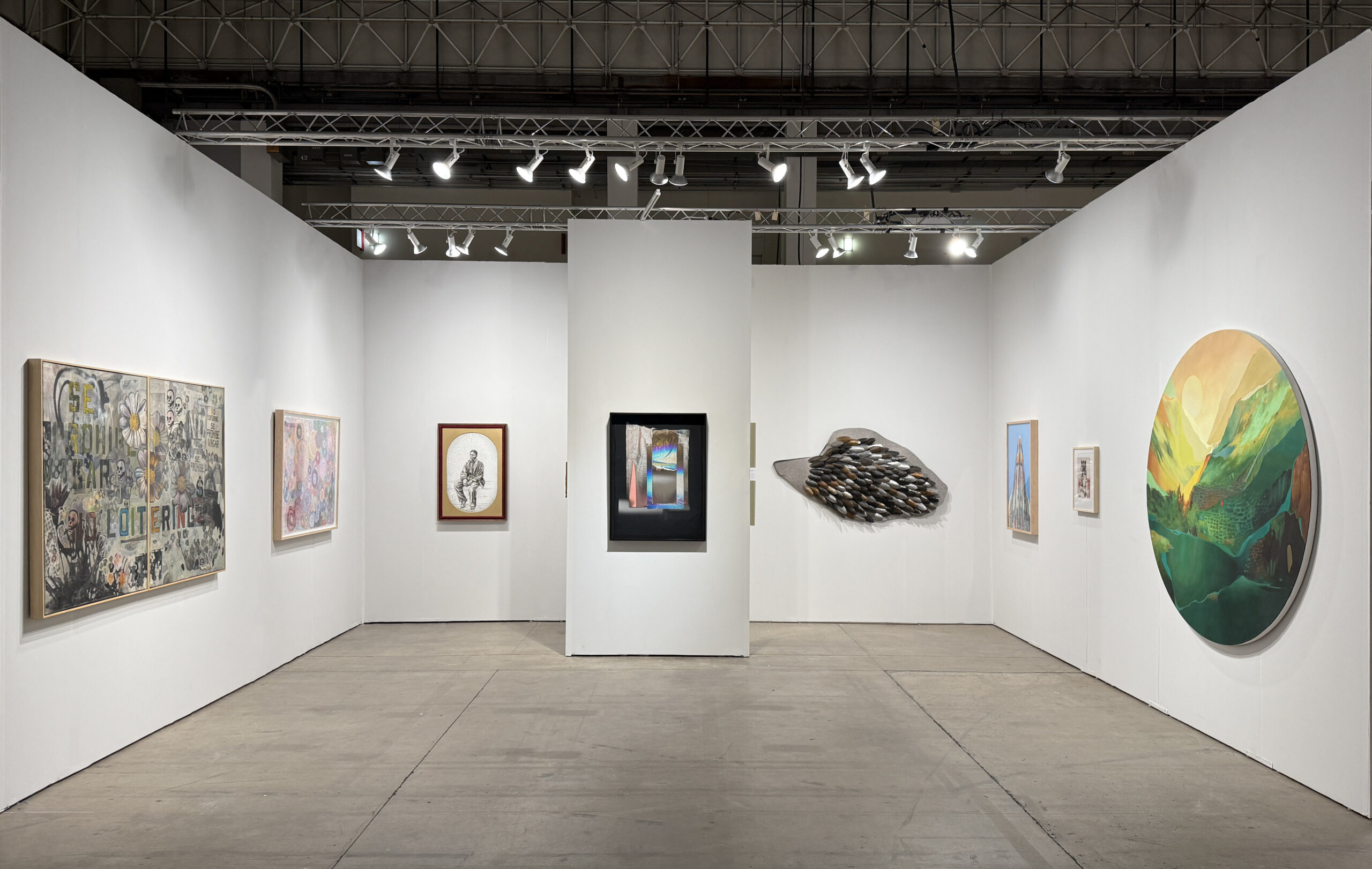 A modern art gallery with white walls displays contemporary art, including paintings, a sculptural piece resembling feathers, and a large circular artwork, all illuminated by bright ceiling lights.