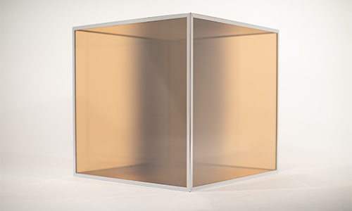 A minimalist, translucent cube with a white frame and amber-tinted sides is displayed on a plain, light background—an elegant piece often featured in modern art exhibitions for its smooth, partially see-through surfaces.