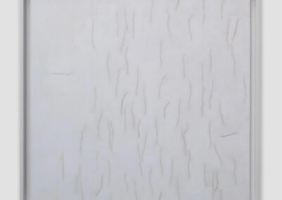 A white canvas with vertical, irregular slits and shallow cuts arranged in rows, creating a textured, minimalist abstract pattern within a simple white frame—an evocative piece by Bell Mills 2025.