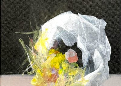 An abstract painting features a white, loosely-formed arch with vibrant yellow, green, and pink brushstrokes at its base, set against a dark background and a pale surface.